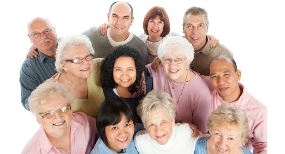 Group of smiling senior people that are all candidates for an implant-supported denture.